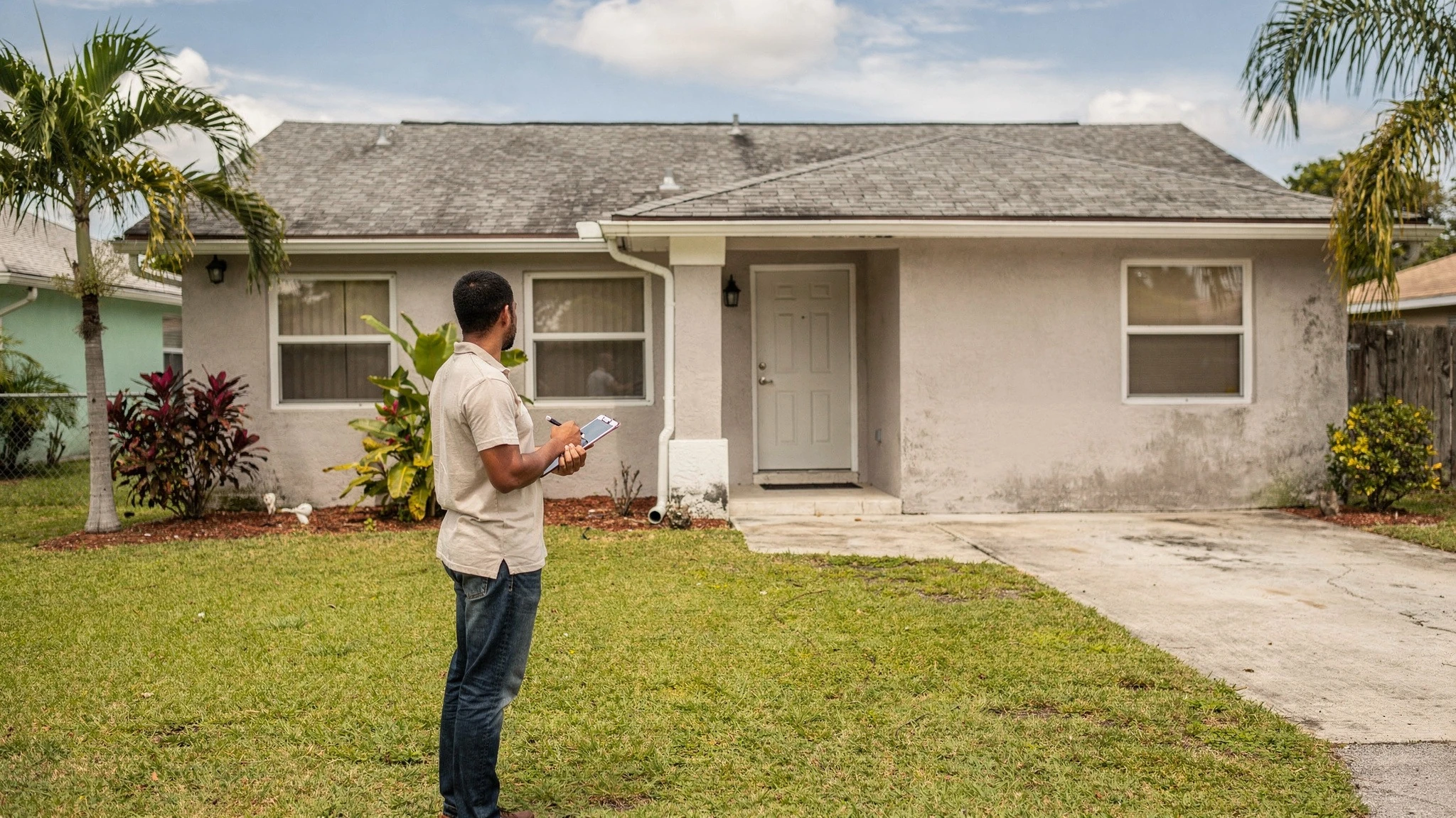 A calm first-time buyer looking thoughtfully at a home, presented neutrally, considering it as more than a photo